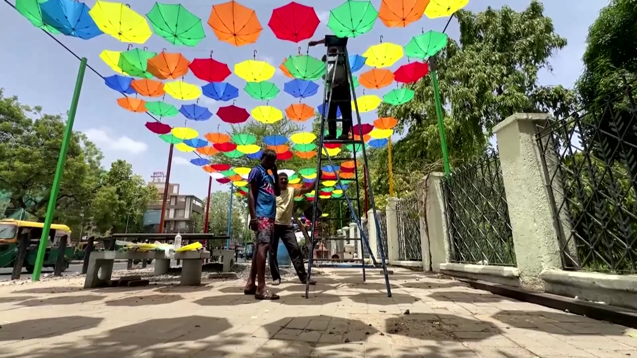 Colorful umbrellas shelter Indians from heat wave