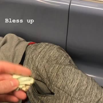 Man puts twenty dollars in pocket of sleeping man