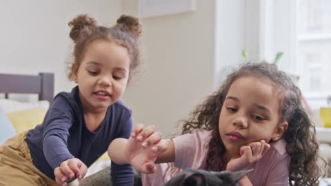 Kids playing with a cute black cat