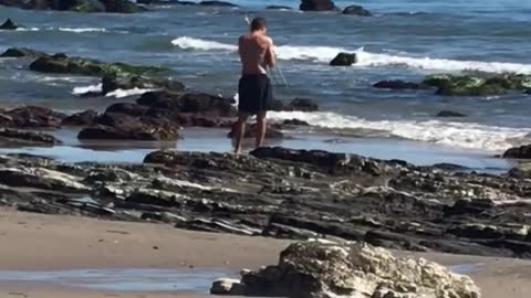 Guy on the beach playing a trombone for the ocean