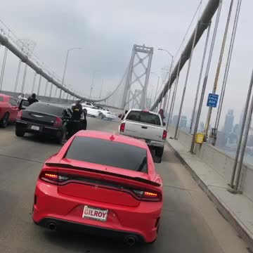 Cars block bridge while dangerously making doughnuts