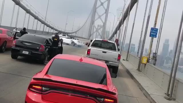 Cars block bridge while dangerously making doughnuts