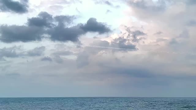The blue sea and the red car are like pictures