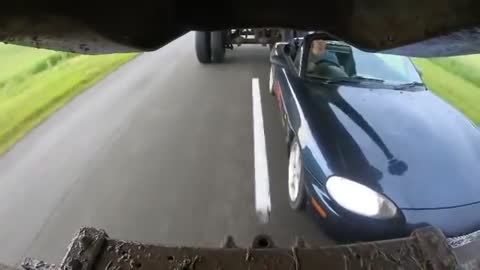 Miata driving underneath a truck