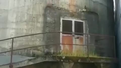 White shirt barefoot standing on silo side flips into pile of dirt