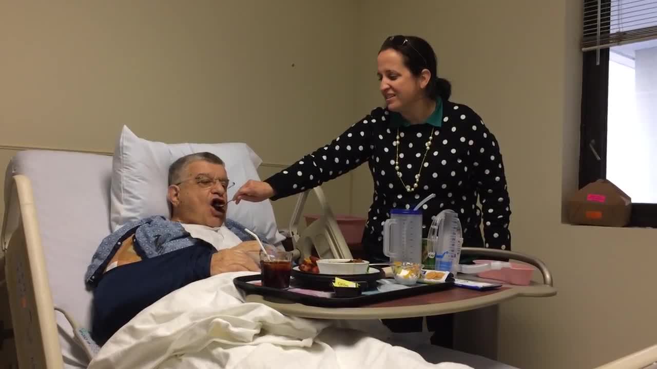 Allison feeding Dan 3.18 shoulder surgery