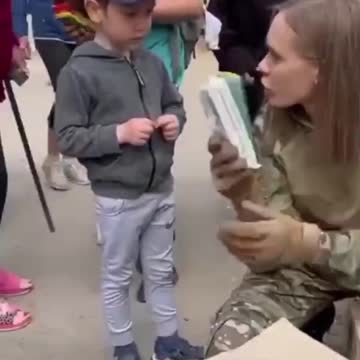 Russian soldier handing out cookies to kid