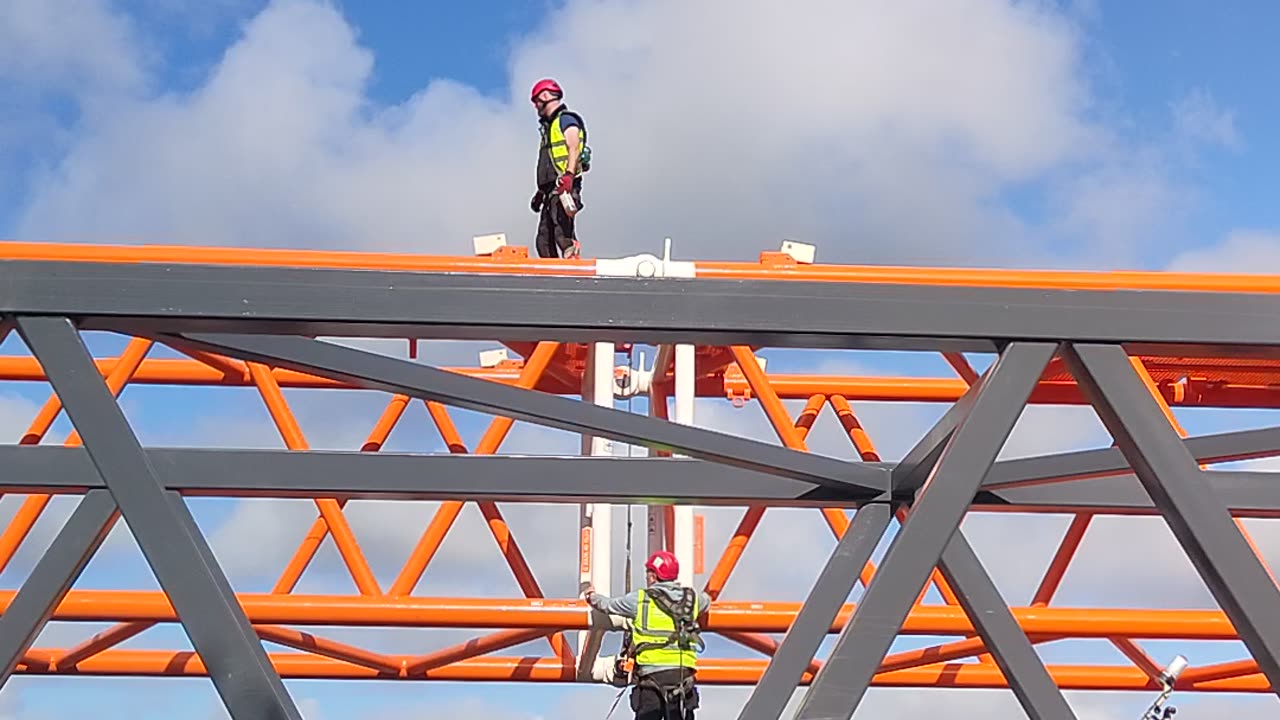 Workman assembling a large Liebherr Orange Crane Scotland