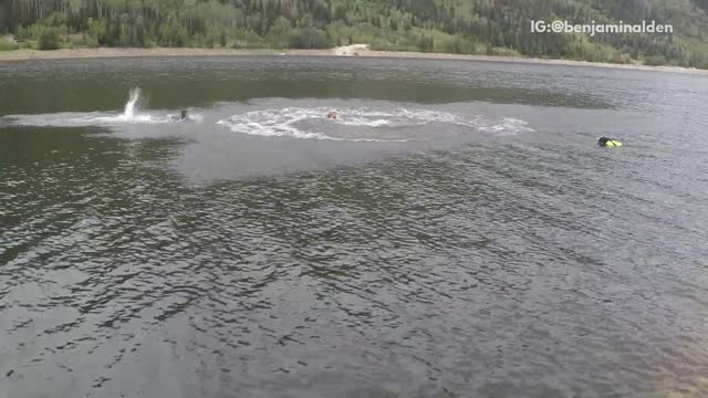 Man red shirt rope swings cannon ball to lake