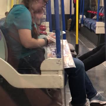 Woman in blue with glasses eating boogers