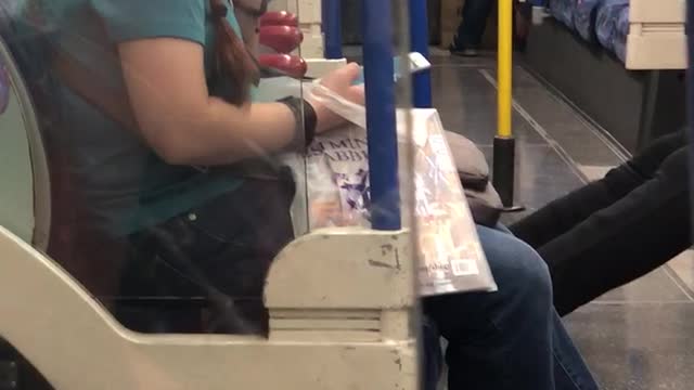 Woman in blue with glasses eating boogers