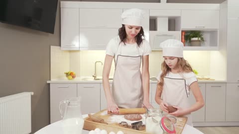 MOTHER TEACHING DAUGHTER HOW TO MAKE DOUGH BETTER