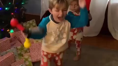 Little kid hits her brother to his head.