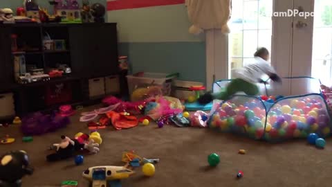 White shirt kid jumps into ball pit hits head on door