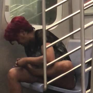 Short red hair woman subway picking at toenails