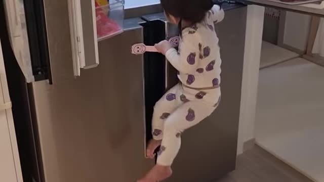 Baby climbing the refrigerator