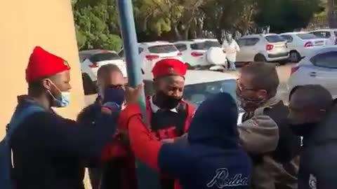 A learner wearing EFF regalia being manhandled