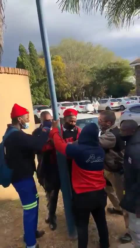 A learner wearing EFF regalia being manhandled