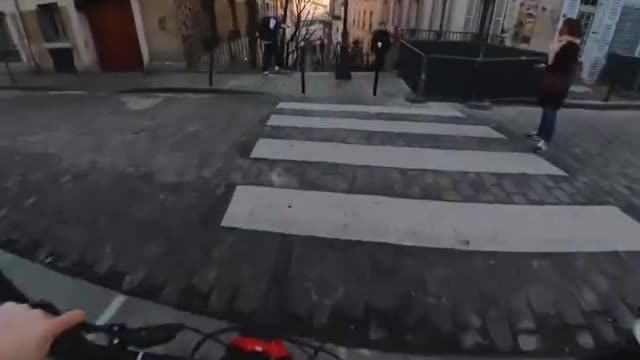 RUSHING TO AN APPOINTMENT ON A MOUNTAIN BIKE ON THE COBBLE STONE STREETS OF PARIS