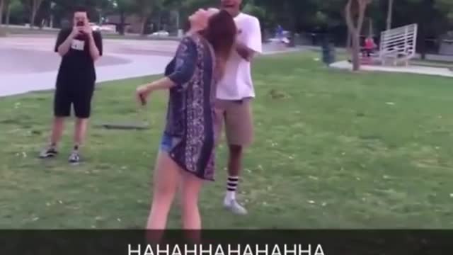 Guy tries to kick water bottle off girls head