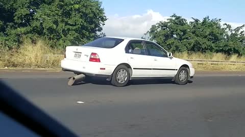 Car Drags Muffler down Highway