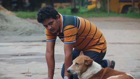 Man pretending to be a Dog sitting beside a Dog