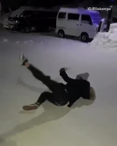 Girl in all black slips on snow doesnt drop drink