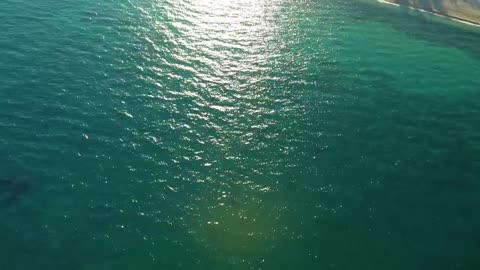 Flying over the azure blue water of a beach