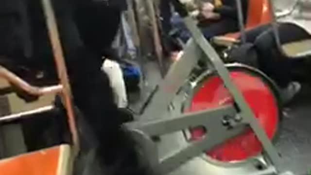 Man rides indoor exercise bike on subway train