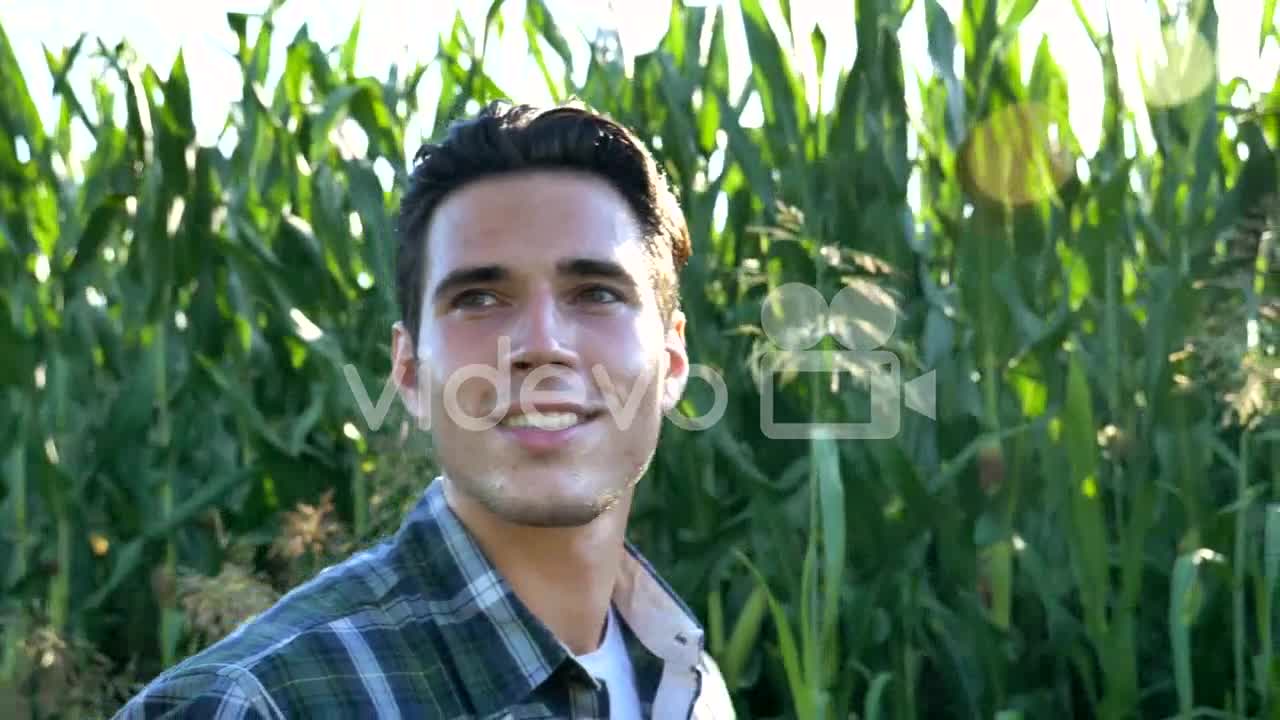 Portrait of a happy young farmer holding fresh vegetables in a basket