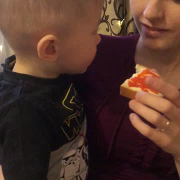 Boy eating a sandwich with red caviar