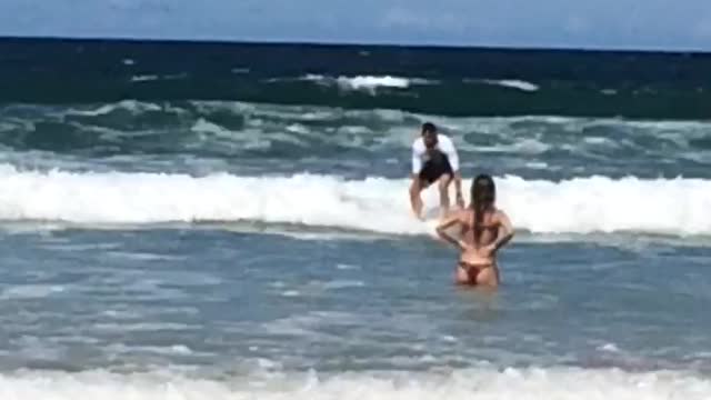 White shirt guy slowly rides surfboard nowhere and falls off