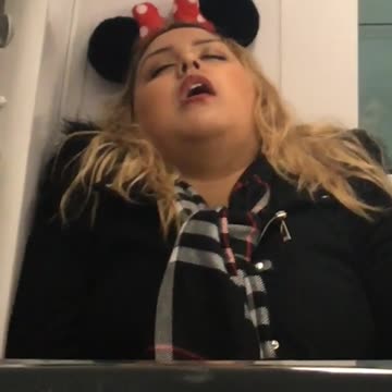 Blonde girl in minnie mouse ears asleep in back of train