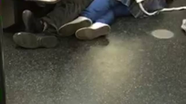 Couple falls asleep on the corner of the floor inside subway train