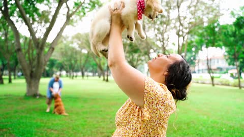 The dog is playing with his mistress very happily and he is also kissing the mistress's lips.