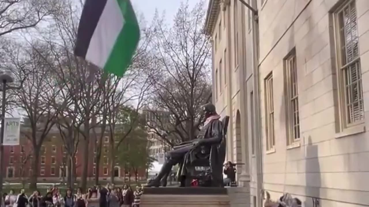 Harvard students cheer as they replace an American Flag with a Palestinian Flag.