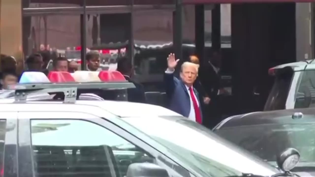 President Trump sporting a red tie gives a wave leaving Trump Tower this morning