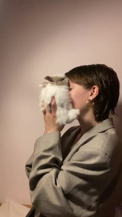 .Woman Holding a Rabbit Close to Her Face