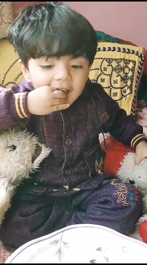 kid playing with tedy bear