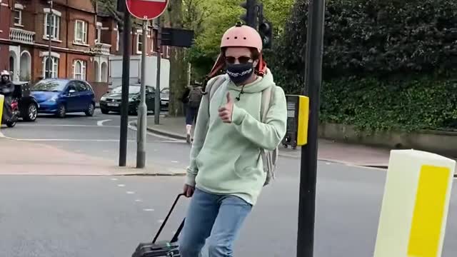 Guy Rides Through the Park on his Hoverboard While Carrying Suitcase