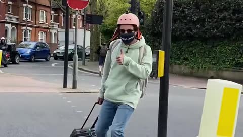 Guy Rides Through the Park on his Hoverboard While Carrying Suitcase