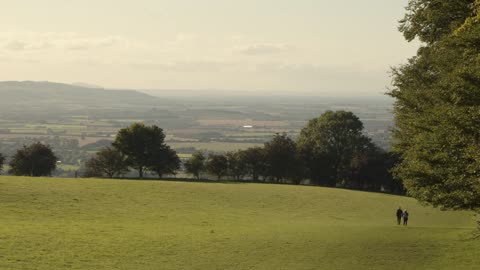 Two People Walking Down Hill with View