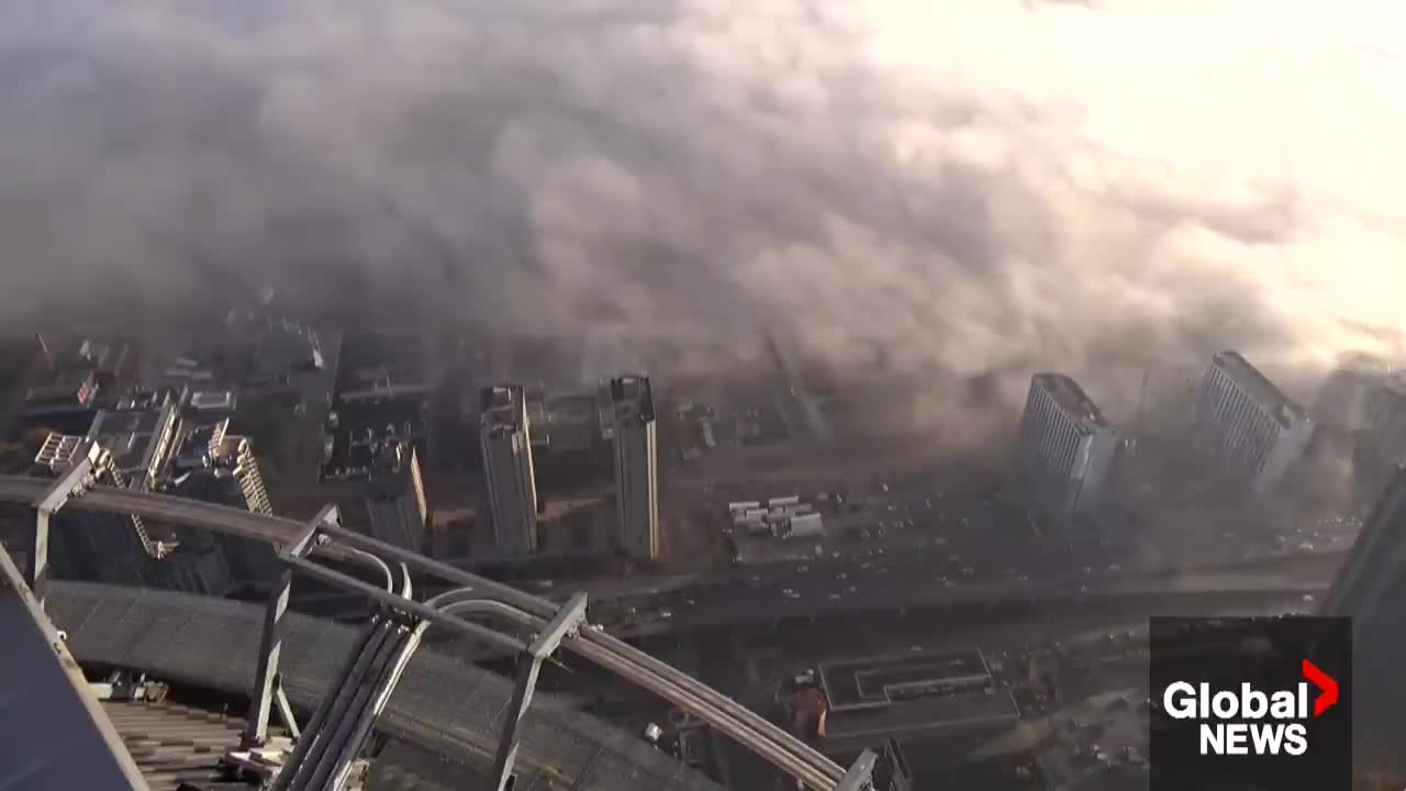 Wall of fog rolls across Toronto from Lake Ontario, creating an eerie scene