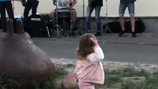 Girl dances to music of street musicians in the old city