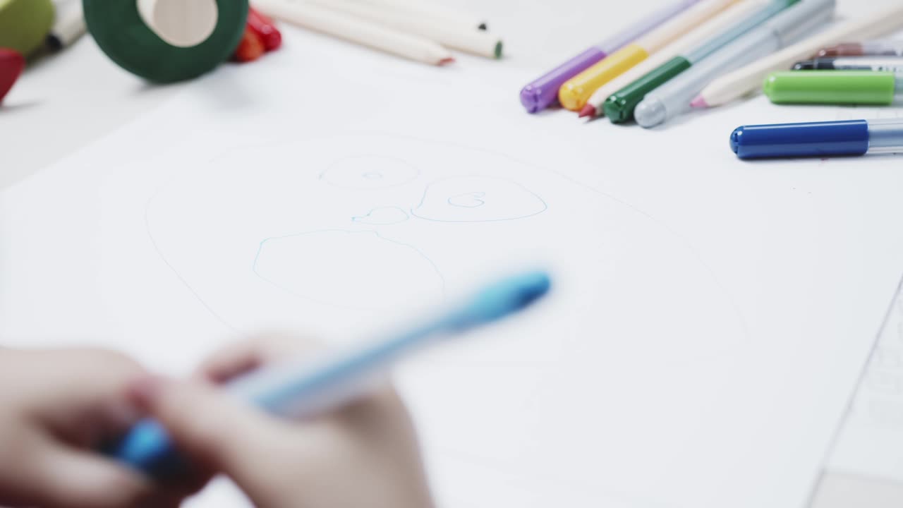 A Young Girl Using Coloring Pen To Draw On A White Paper