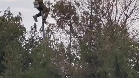 Ukrainian soldier taking down a communist flag in an area liberated from the Russian Army.