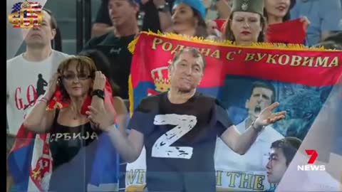 Novak Djokovic's father, pictured next to a flag with Vladimir Putin