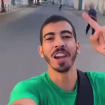 Palestinian man celebrates on the streets of Gaza as Hamas fires rockets head for Israel