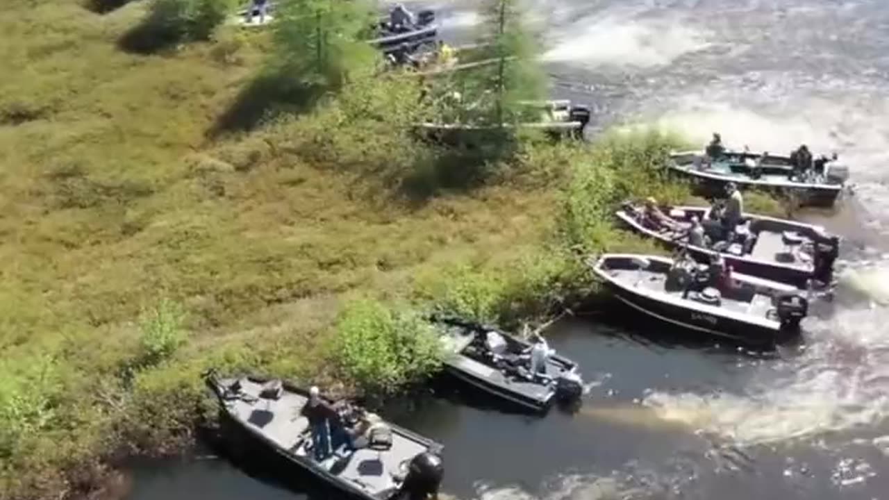 Boat owners moving a large floating island out of the way on Wisconsin's Lake