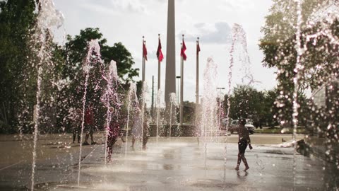 A baby playing in fountain
